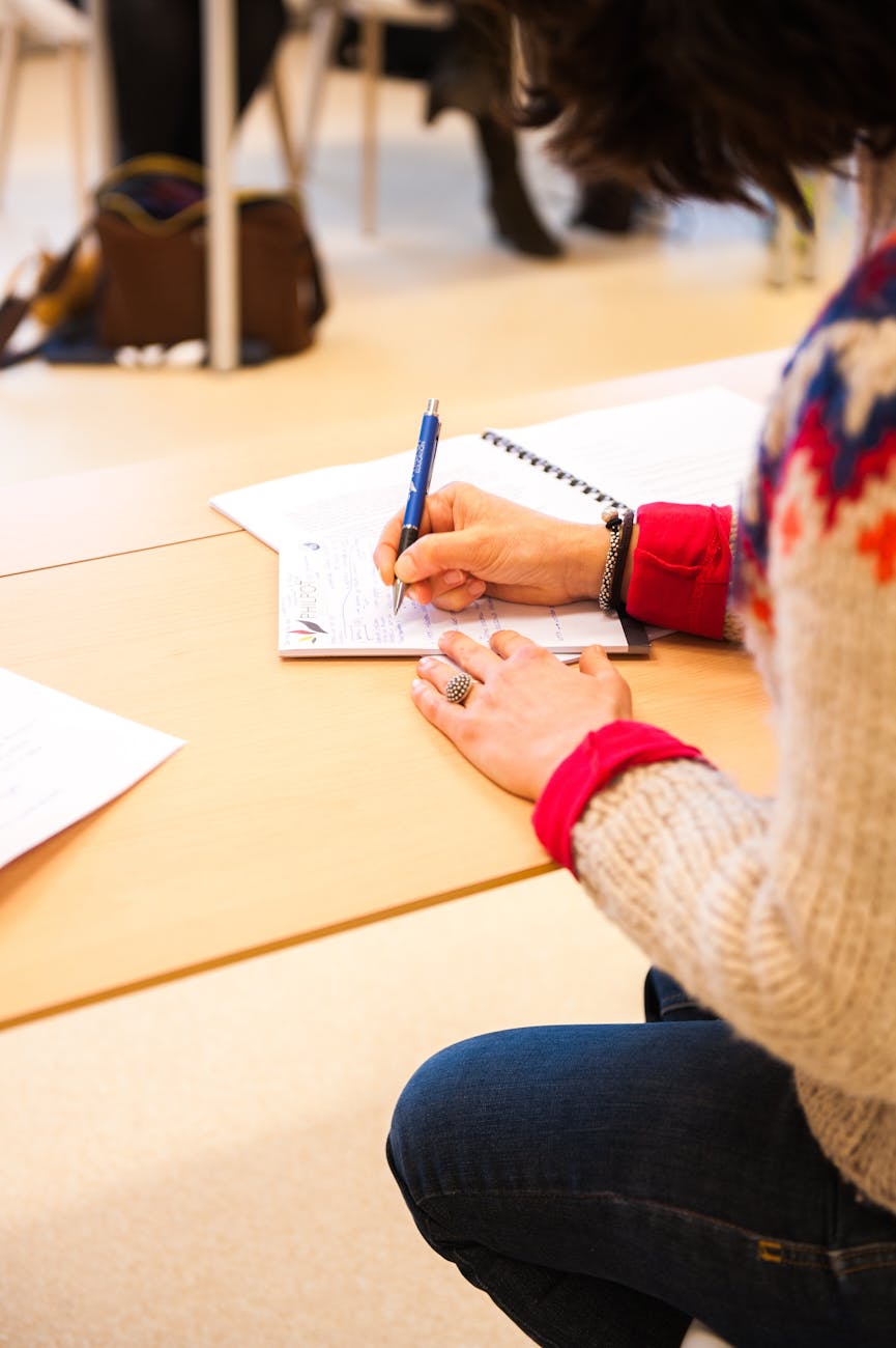 woman holding blue pen writing on paper adhd and autism assessment consultation