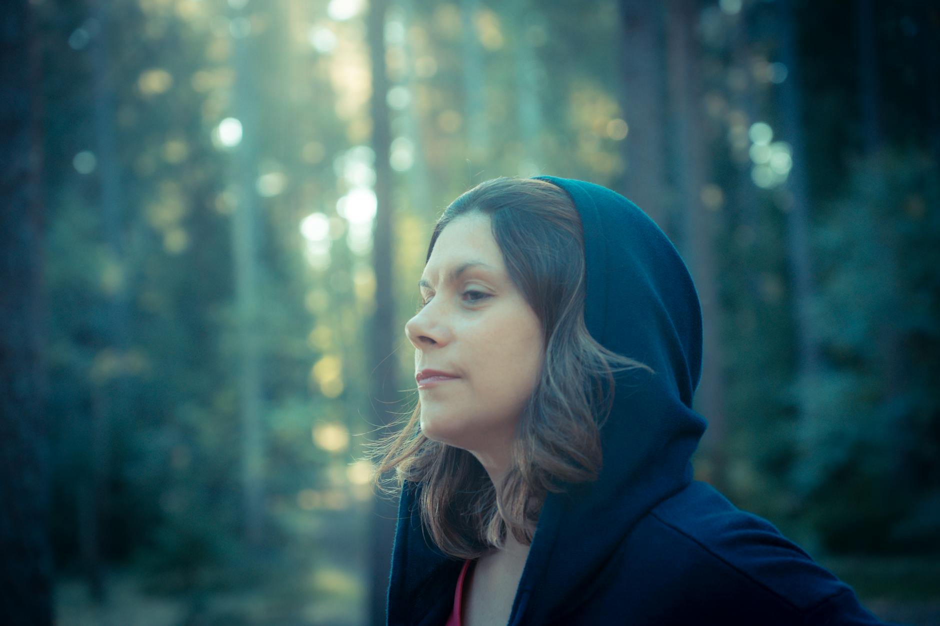 a woman in a hoodie looking up in the woods adhd testing
