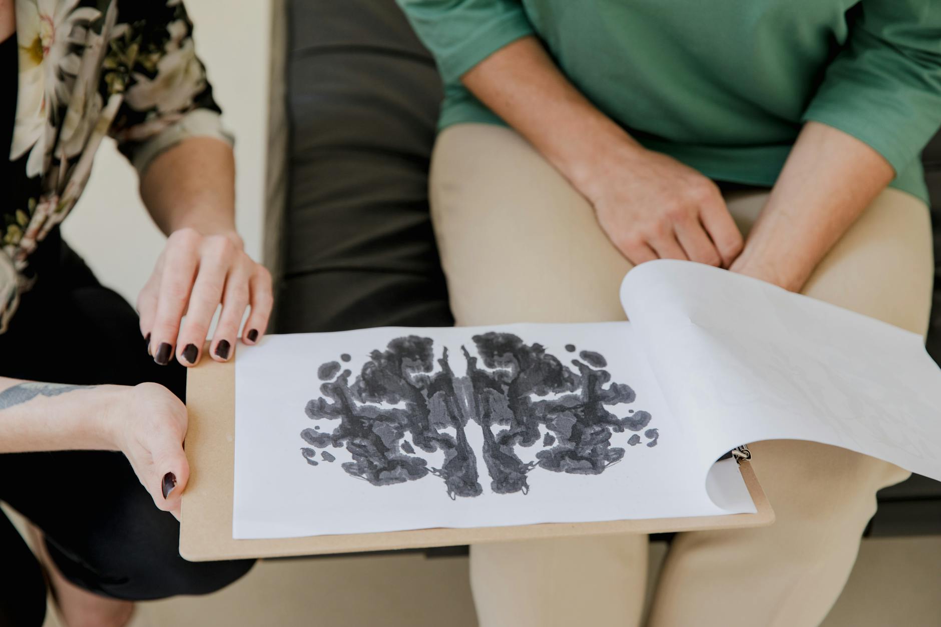 a person holding a clipboard with artwork neuroaffirming trauma-informed care